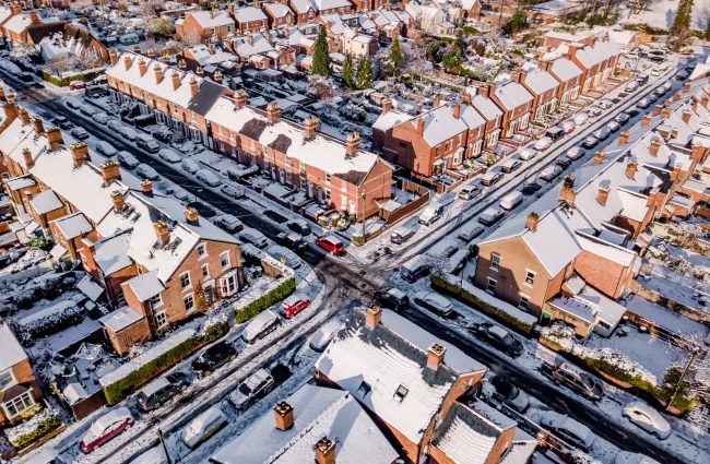 Aerial view of snow covered traditional housing suburbs in England. Snow, ice and adverse weather conditions bring things to a stand still in the housing estates of a British suburb